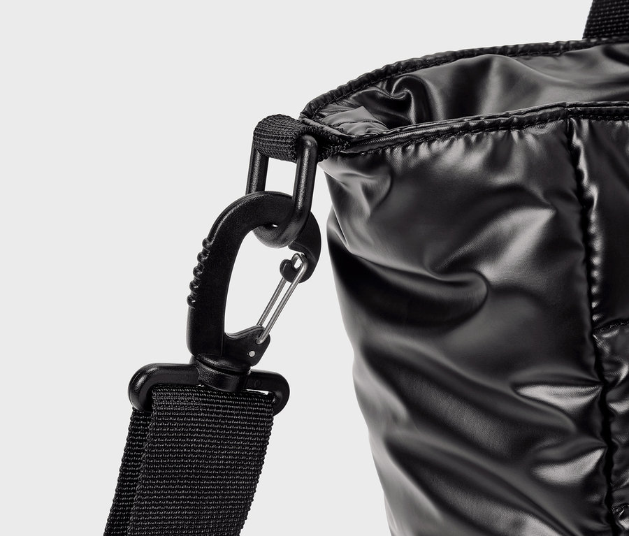 Detailaufnahme einer glänzenden schwarzen Tasche mit Karabiner.