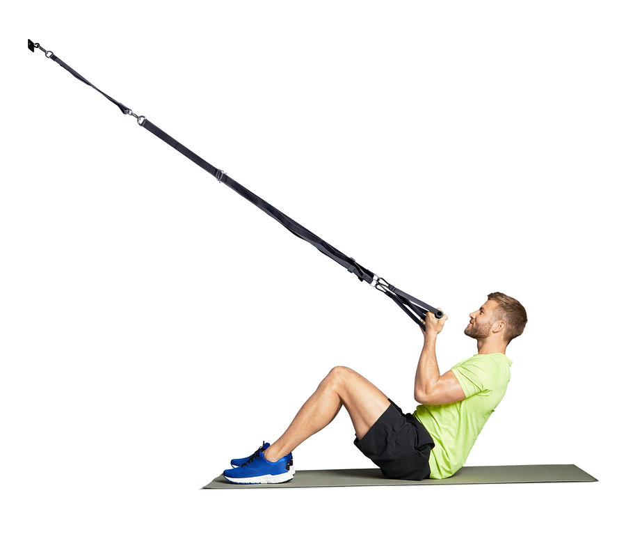 Mann trainiert mit dem Schlingentrainer.