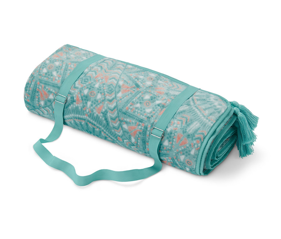 Eine zusammengerollte XL-Picknickdecke mit blaugrünem und orangefarbenem geometrischem Muster und Riemen.