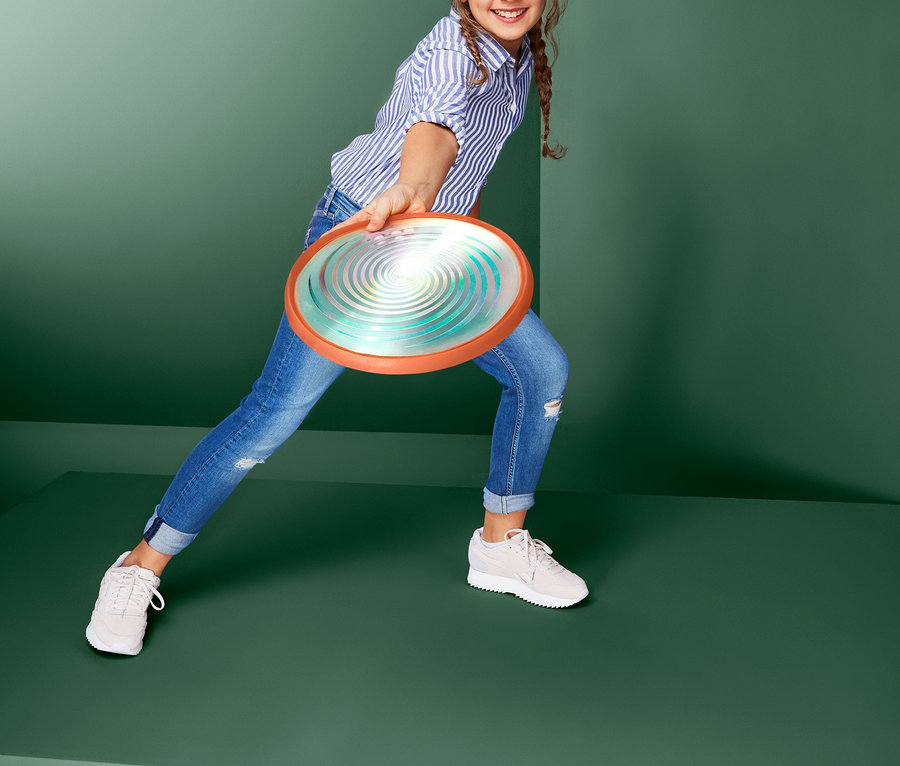Mädchen wirft LED-Wurfscheibe.