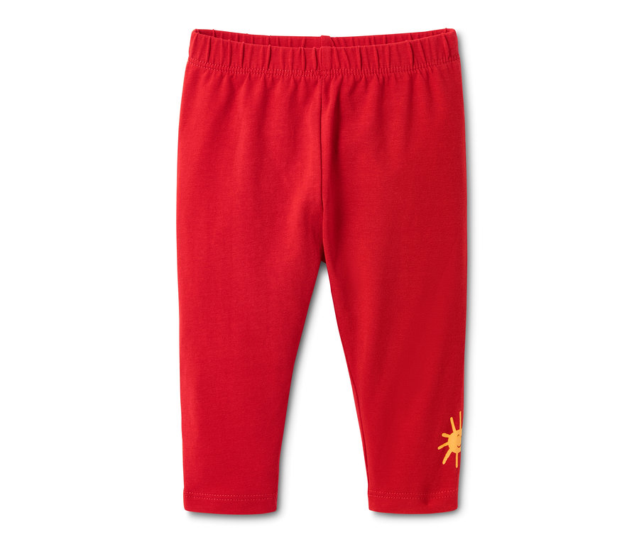 Eine rote Jersey-Leggings aus Bio-Baumwolle mit einem Sonnenaufdruck am Bein.