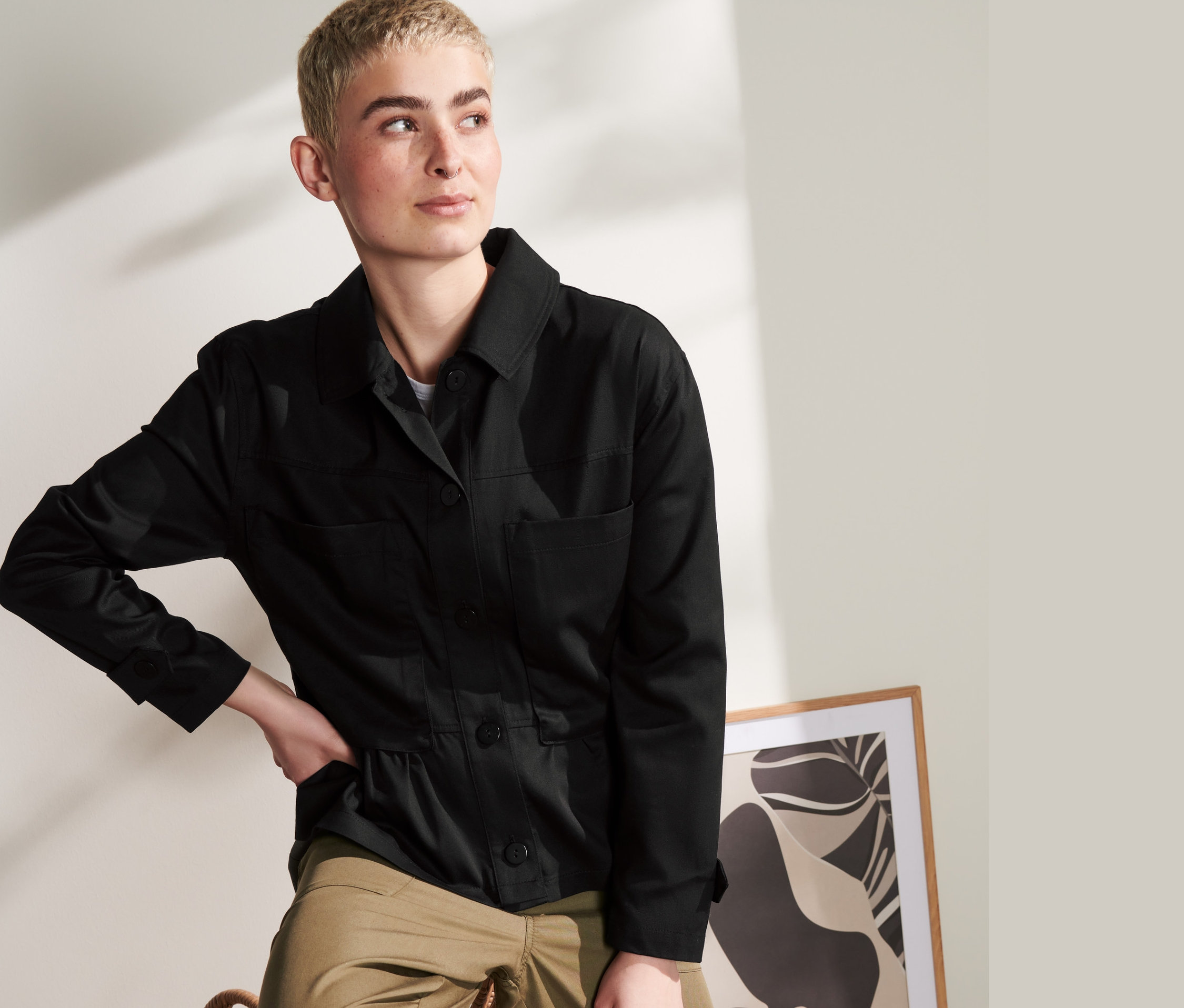 Frau posiert in schwarzem Overshirt und Khaki-Hosen.