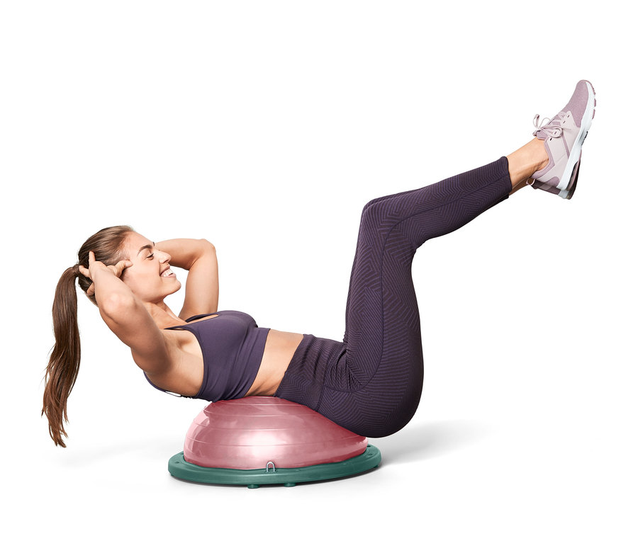 Frau macht Crunches auf einem Balance-Ball.