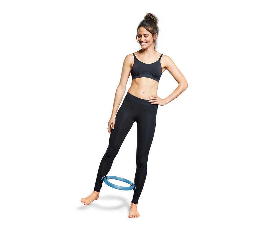 Frau trainiert mit blauem Pilatesring.