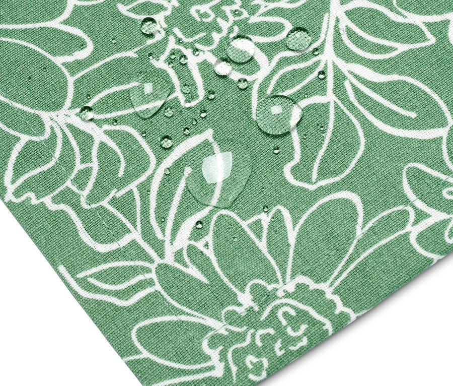 Detail einer Ecke einer grünen Outdoor-Tischdecke mit weißem Blumenmuster und Wassertropfen.
