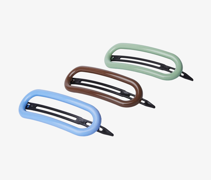 Drei Haarspangen liegen auf weißem Grund.