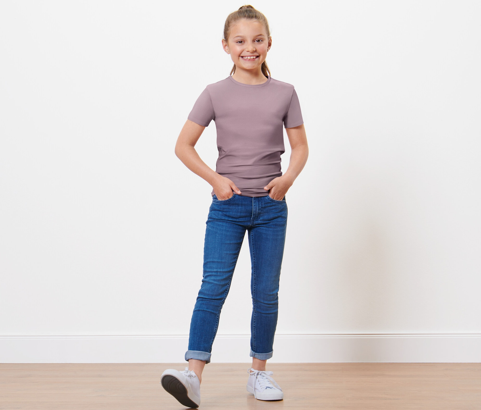 Mädchen posiert in 3 Kinder-T-Shirts.