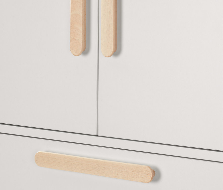Detailansicht eines weißen Waschmaschinenschranks mit aufklappbarer Arbeitsfläche und Holzgriffen.