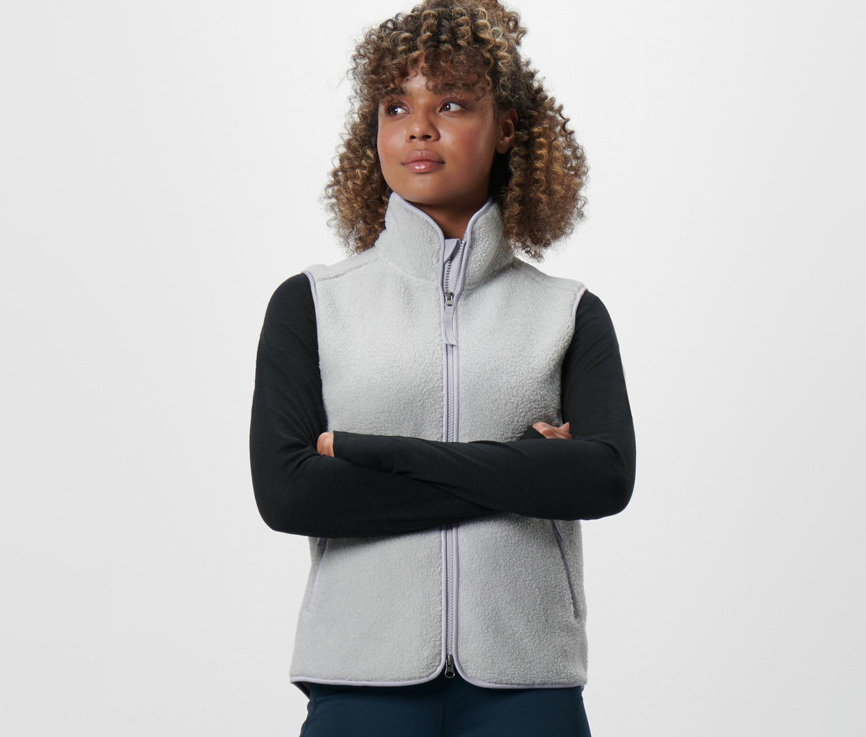 Frau mit verschränkten Armen trägt eine Teddy-Weste.