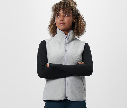 Frau mit verschränkten Armen trägt eine Teddy-Weste.