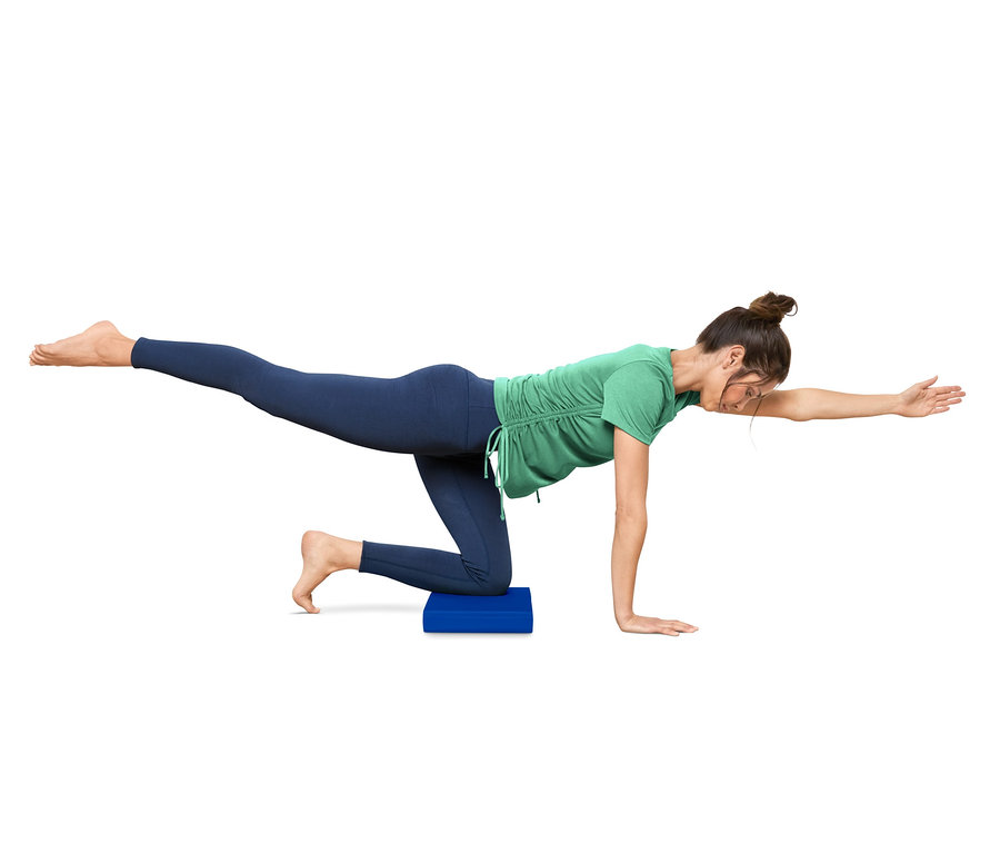 Frau macht Übungen auf einem Balance-Pad.