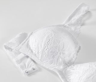 Detailansicht eines weißen Softschalen-BHs mit Spitze.