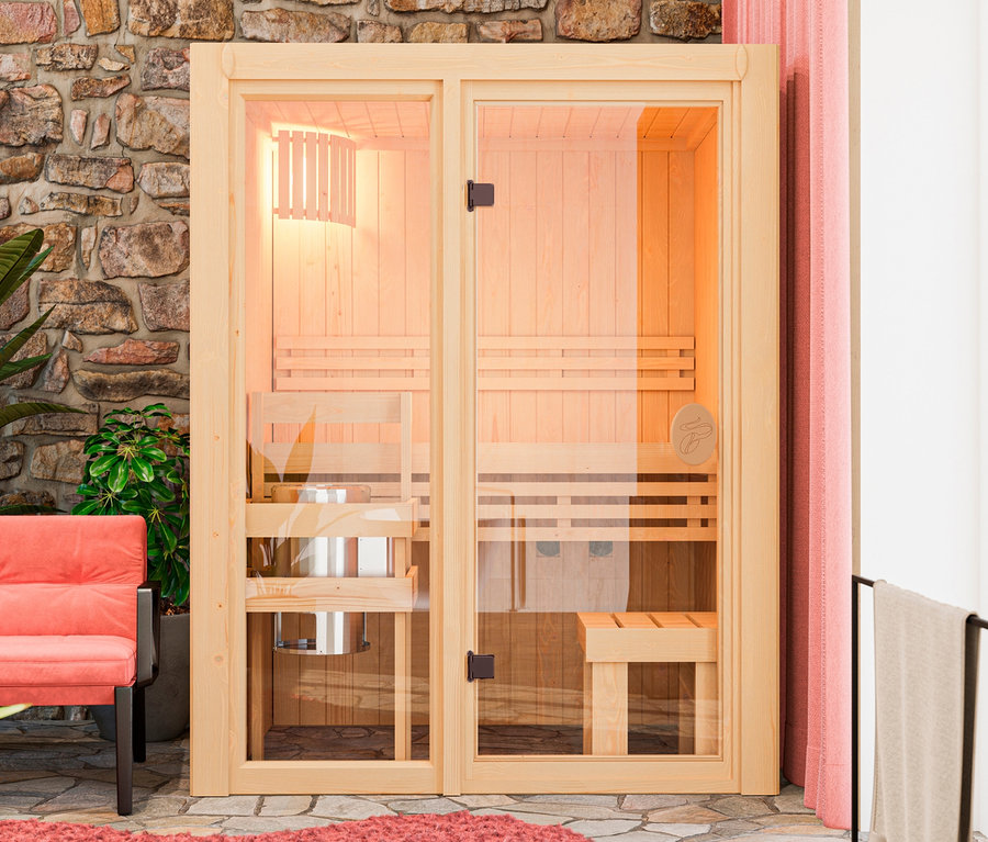 Innenaufnahme mit Karibu Sauna »Vivi 1« mit Bänken, daneben Sessel und Grünpflanzen.