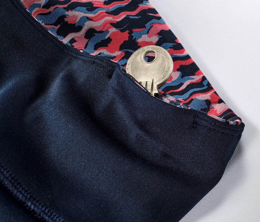 Detail einer Wende-Sporttight in Rosa und Navy mit einem Schlüssel in der Tasche.