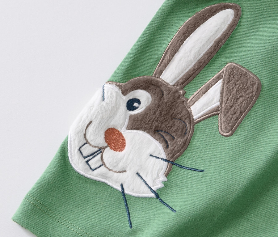 Detailaufnahme eines grünen Kinder-T-Shirts mit einer Hasenapplikation, 2 Kinder-T-Shirts mit Applikation, blau-grün.