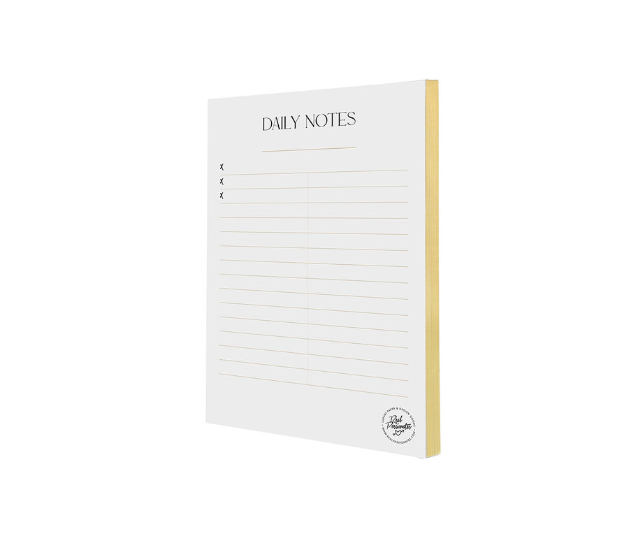 Ein Notizblock mit Goldschnitt »Daily Notes« liegt auf einem weißen Untergrund.
