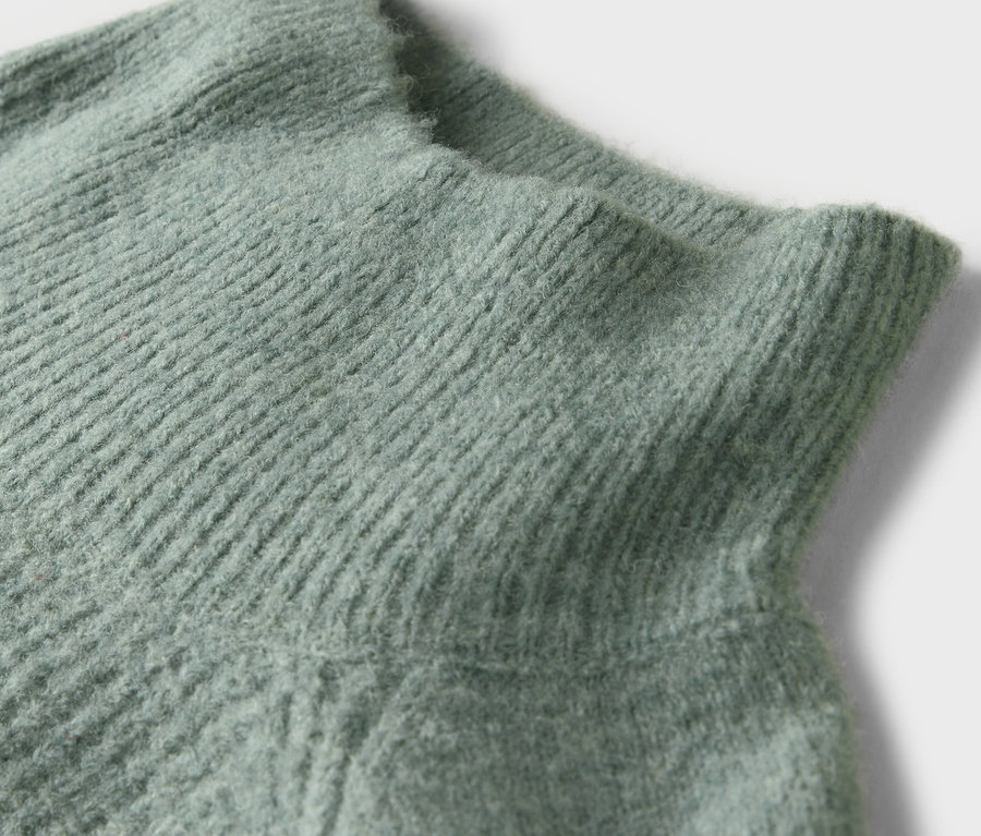 Detailaufnahme eines mintgrünen Rollkragenpullovers.