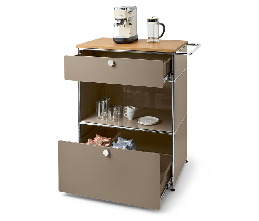 Auf einer braunen Kommode stehen eine Kaffeemaschine und eine French Press. Die untere Schublade ist geöffnet und enthält Kaffeepackungen.