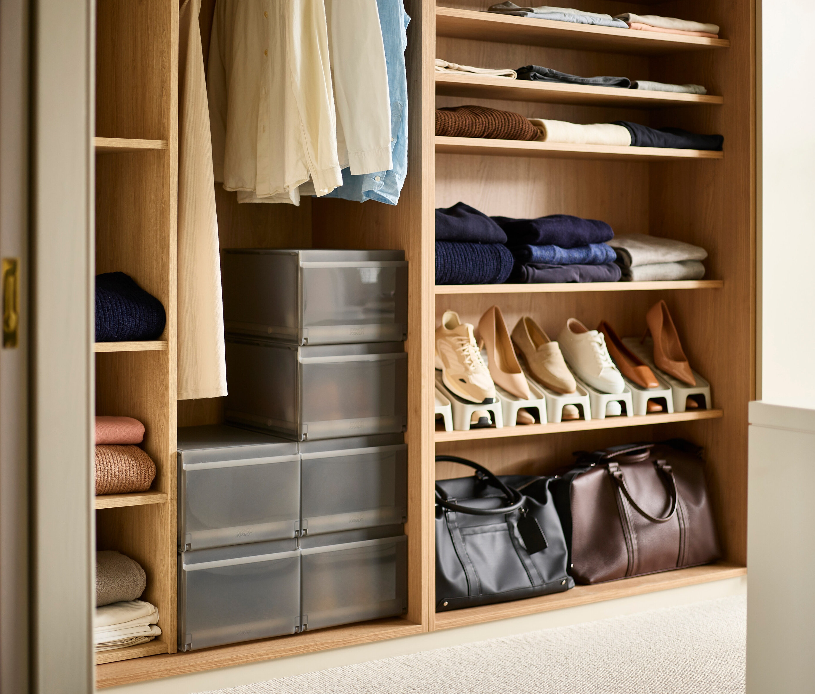 Offener Schrank mit Kleidung, Schuhen und sechs Joseph Joseph Premium-Schuhaufbewahrungsboxen.