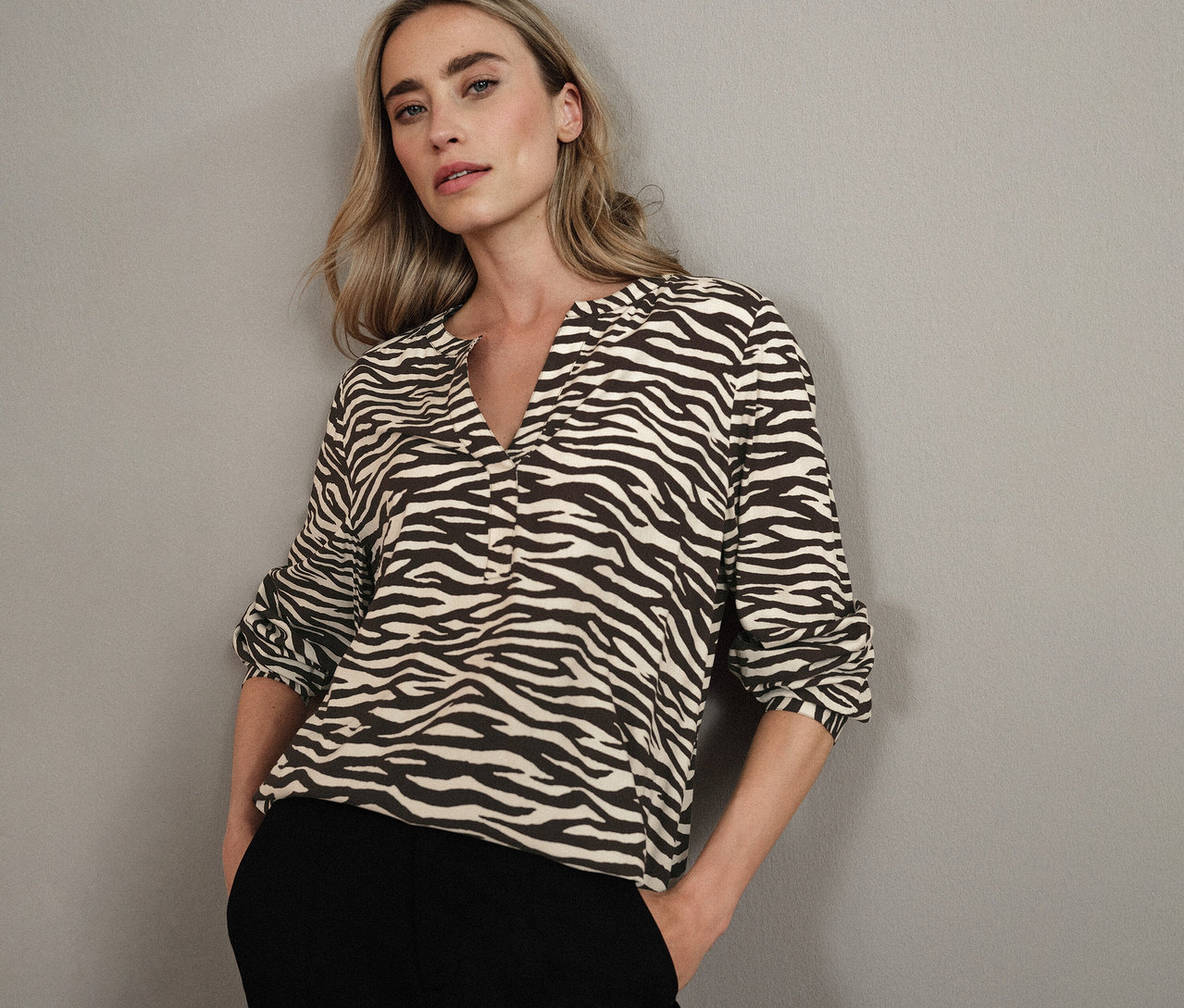 Blonde Frau trägt eine Street One Bluse mit Zebra-Muster.