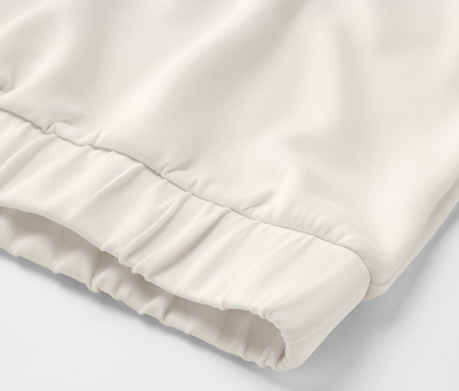 Detailansicht eines cremeweißen Hoodies aus Modal-Mix.
