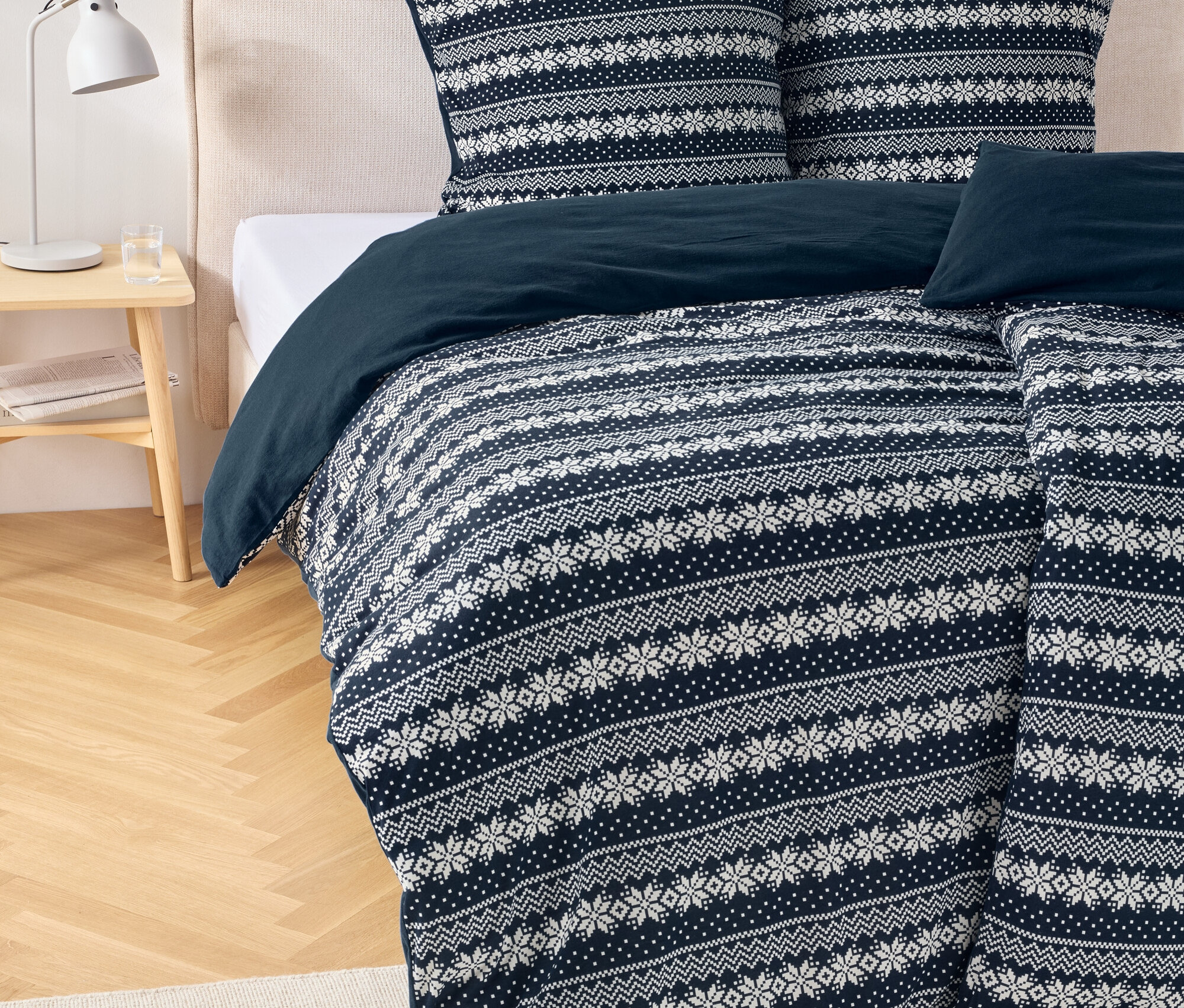 Bettwäsche mit Weihnachtsmuster auf einem Bett.