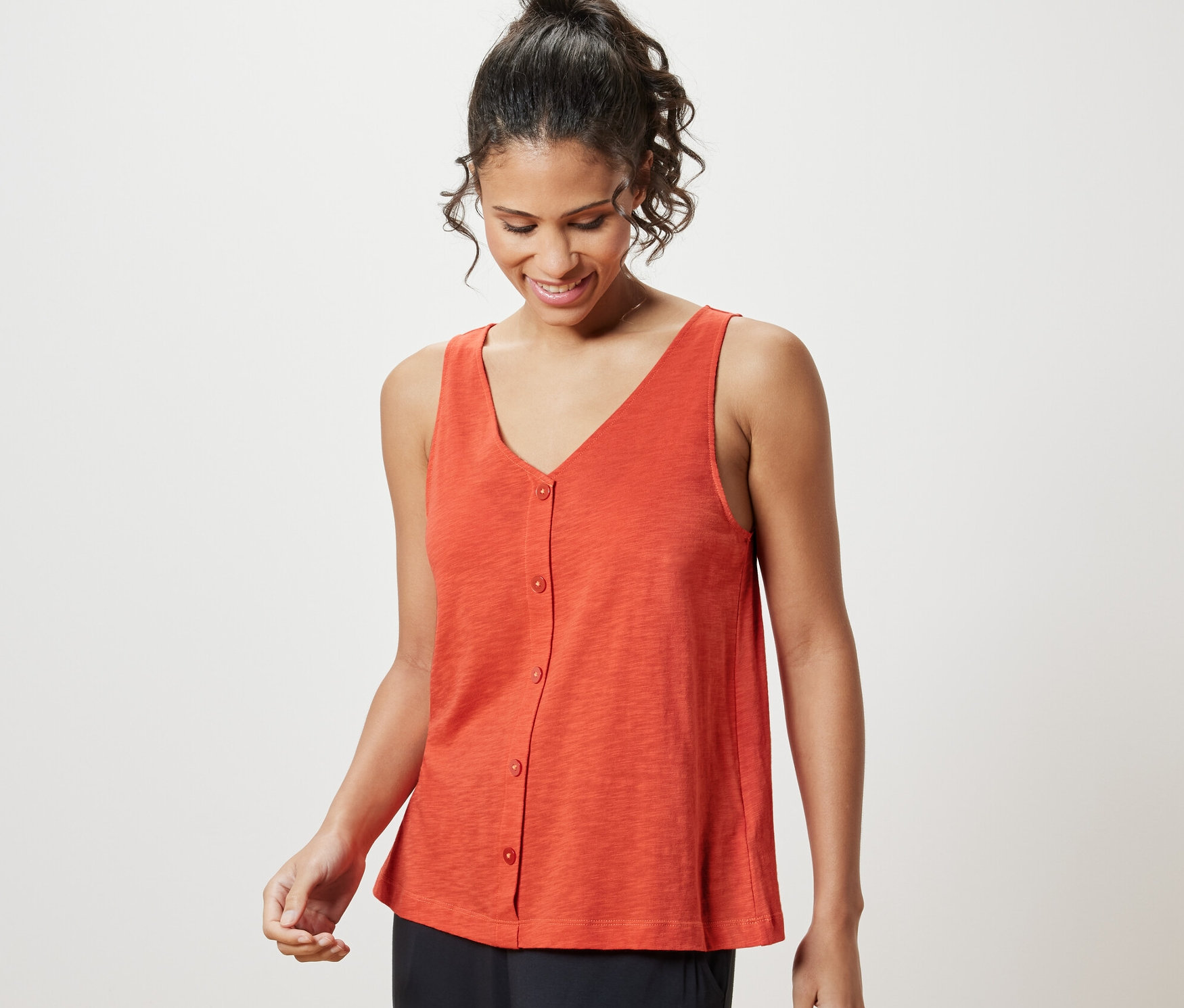 Frau trägt orangefarbenes Top aus Modalmix.