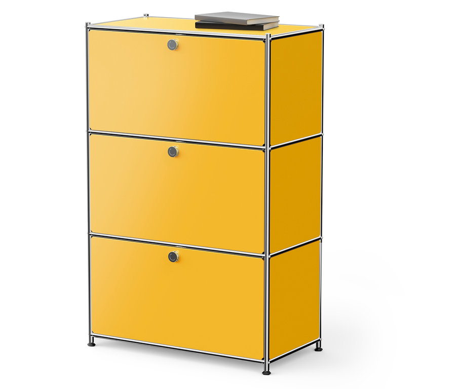 Gelber Schrank mit drei Schubladen und einem Buch darauf.