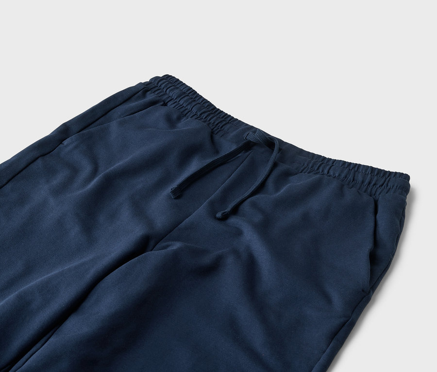 Nahaufnahme einer marineblauen Jogginghose mit Kordelzug und Taschen.