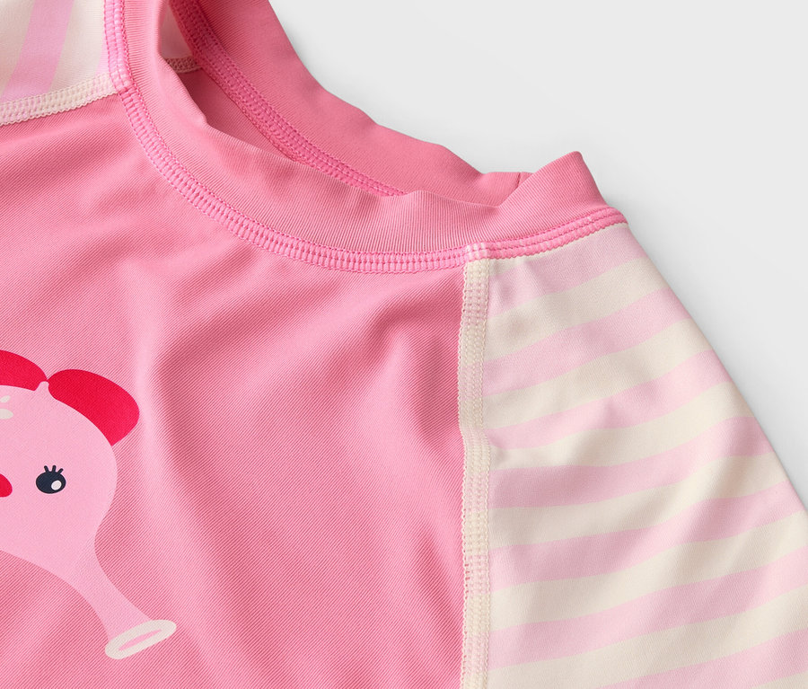 Detailaufnahme eines rosa Oberteils mit einem Elefantenmotiv und gestreiften Ärmeln.