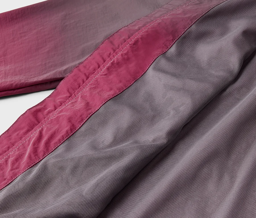 Nahaufnahme von Stoff in Rosa- und Grautönen mit einer rosa Naht.