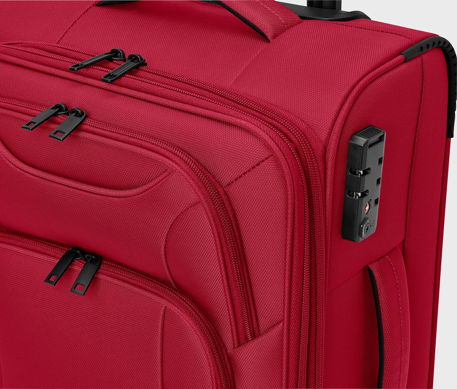 Detailansicht eines roten Stoffkoffers mit schwarzen Reißverschlüssen und einem Zahlenschloss.