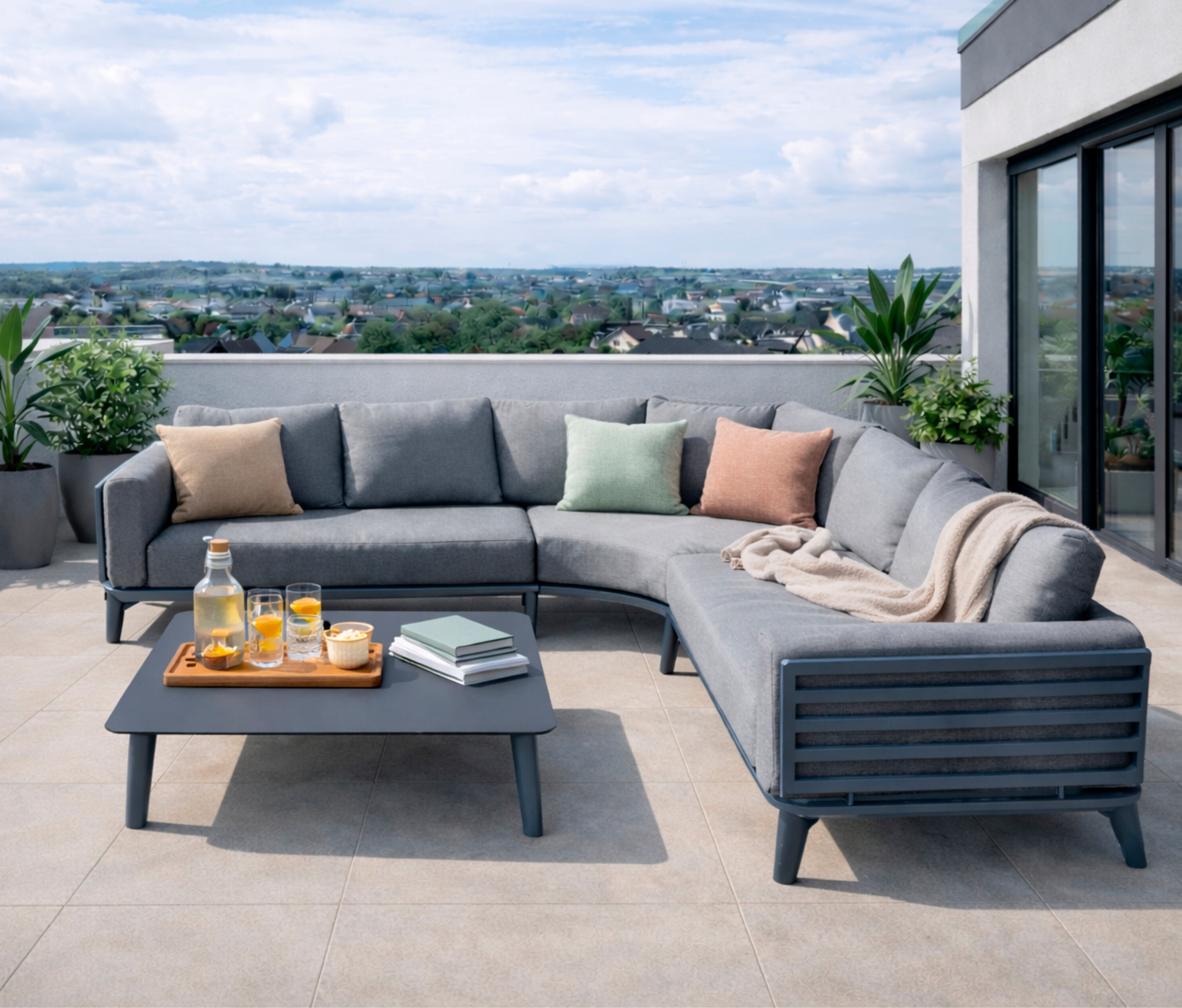Anthrazitfarbene Leco Lounge-Ecke »Moss« mit Tisch auf einer Dachterrasse mit Getränken und Kissen.