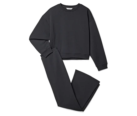 Ein graues Sweatshirt und eine graue Hose liegen auf einem weißen Hintergrund.