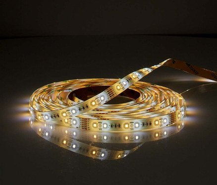 Aufgerollter, leuchtender, smarter LED-Streifen auf einer dunklen Oberfläche.