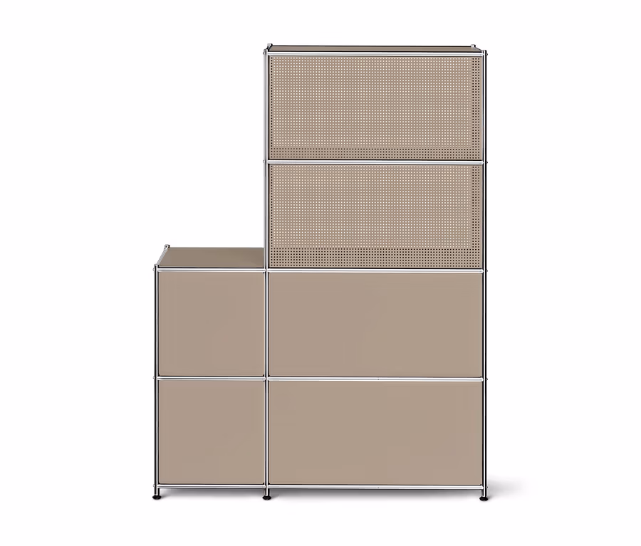 Beiges modulares Regalsystem mit silbernem Rahmen, L-förmig angeordnet. Der höhere rechte Teil hat zwei perforierte obere Module und zwei geschlossene untere Module. Der linke Teil hat ein offenes oberes Modul und ein geschlossenes unteres Modul.