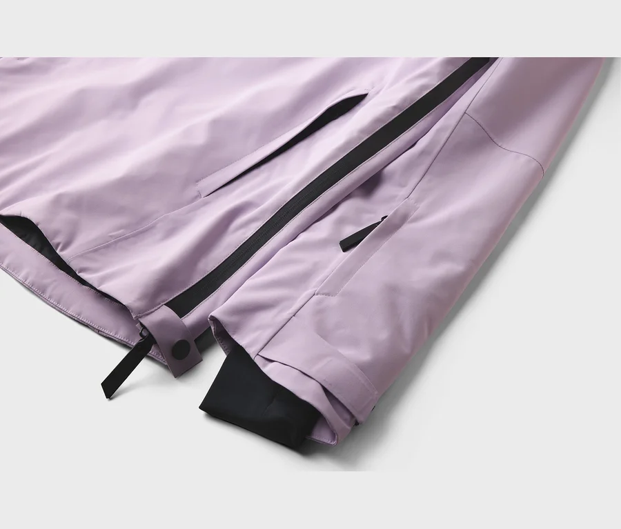 Nahaufnahme einer hellvioletten Jacke mit schwarzen Reißverschlüssen und verstellbaren Ärmelbündchen mit schwarzen Laschen.