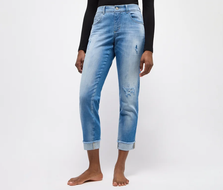 Person trägt hellblaue, zerrissene Angels Denim »Darleen« Jeans mit umgekrempelten Knöcheln und ein schwarzes Langarmshirt, barfuß stehend.