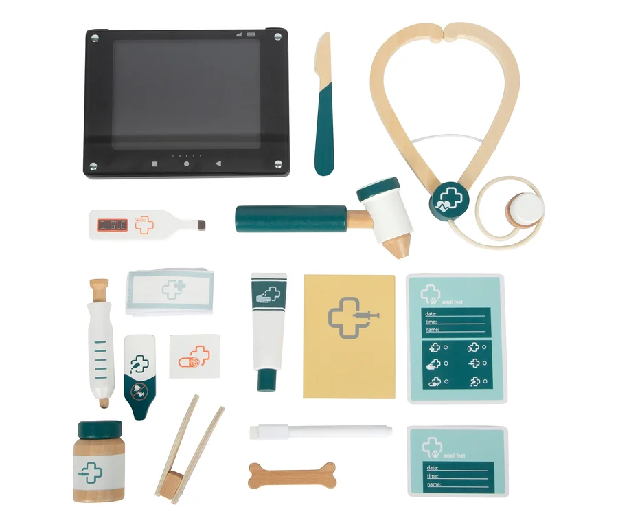 Ein small foot Tierarzt-Set "Hund" mit 15 Teilen, darunter ein schwarzes Tablet, ein Stethoskop, ein Thermometer, ein Reflexhammer, eine Spritze, eine Salbe, eine Bandage, eine Pinzette, eine Flasche, ein Knochen, ein Skalpell, ein Stift und zwei Patientenakten.