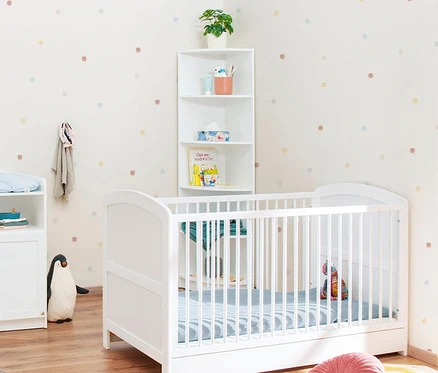 Kinderzimmer mit weißem Kinderbett, weißem Pinolino Eckregal und Wickeltisch.