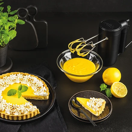 Zitronentarte mit Baiser, Schüssel mit Eigelbcreme und schwarzer WILFA Handmixer SMOOTH-MIX.