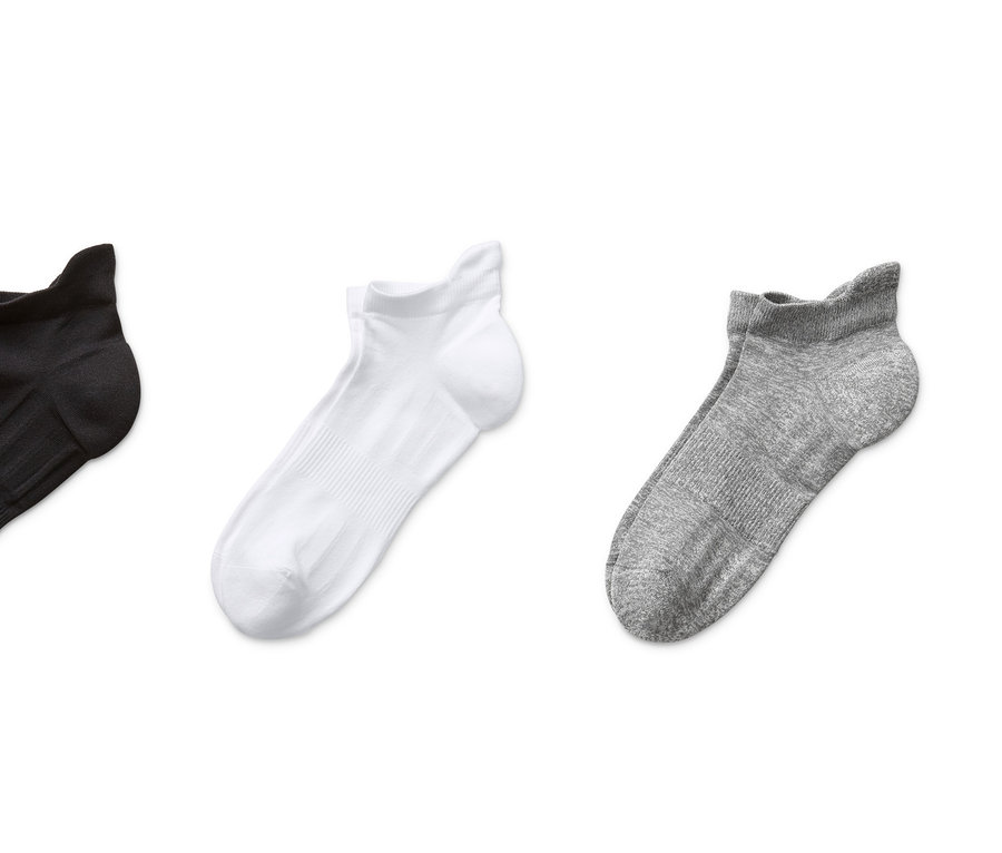 Drei Paar Funktions-Laufsocken in Schwarz, Weiss und Grau auf weissem Hintergrund.