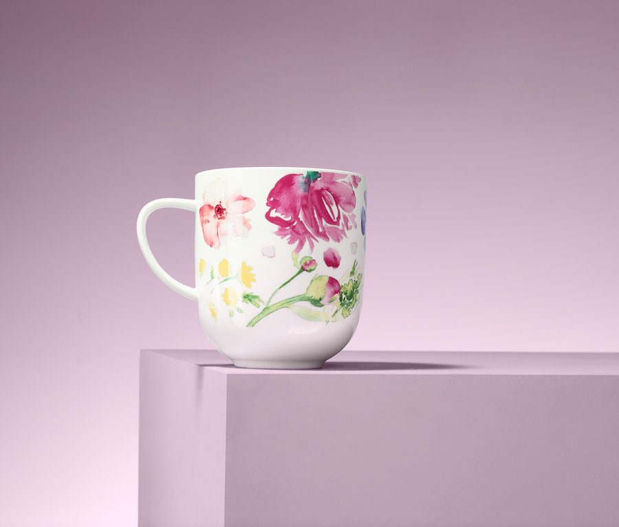 Ein Jumbobecher mit Blumenmuster auf einem lila Hintergrund.