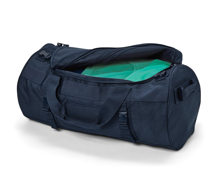 Geöffnete blaue Reisetasche und Rucksack mit grüner Kleidung darin.