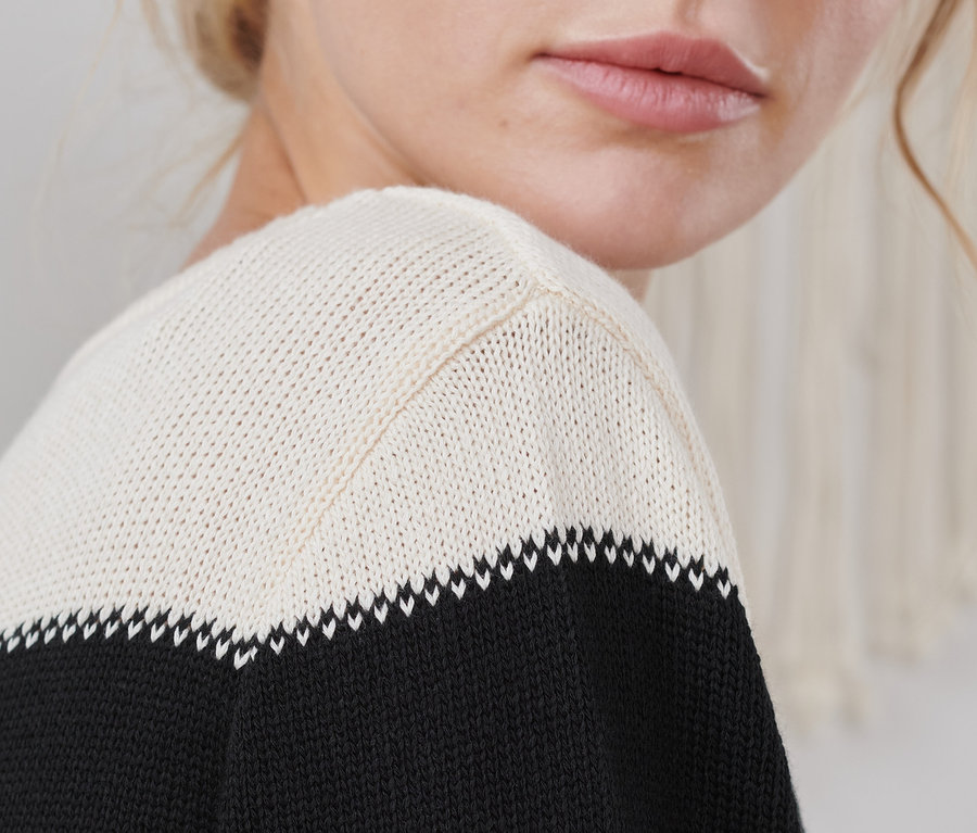 Detailaufnahme einer jungen Frau, die einen Strickpullover trägt.