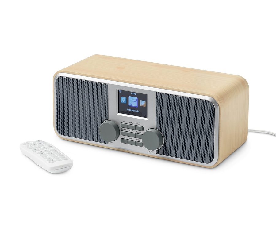 Ein naturfarbenes WLAN-Internetradio mit Farbdisplay und Fernbedienung liegt auf einem weißen Hintergrund.