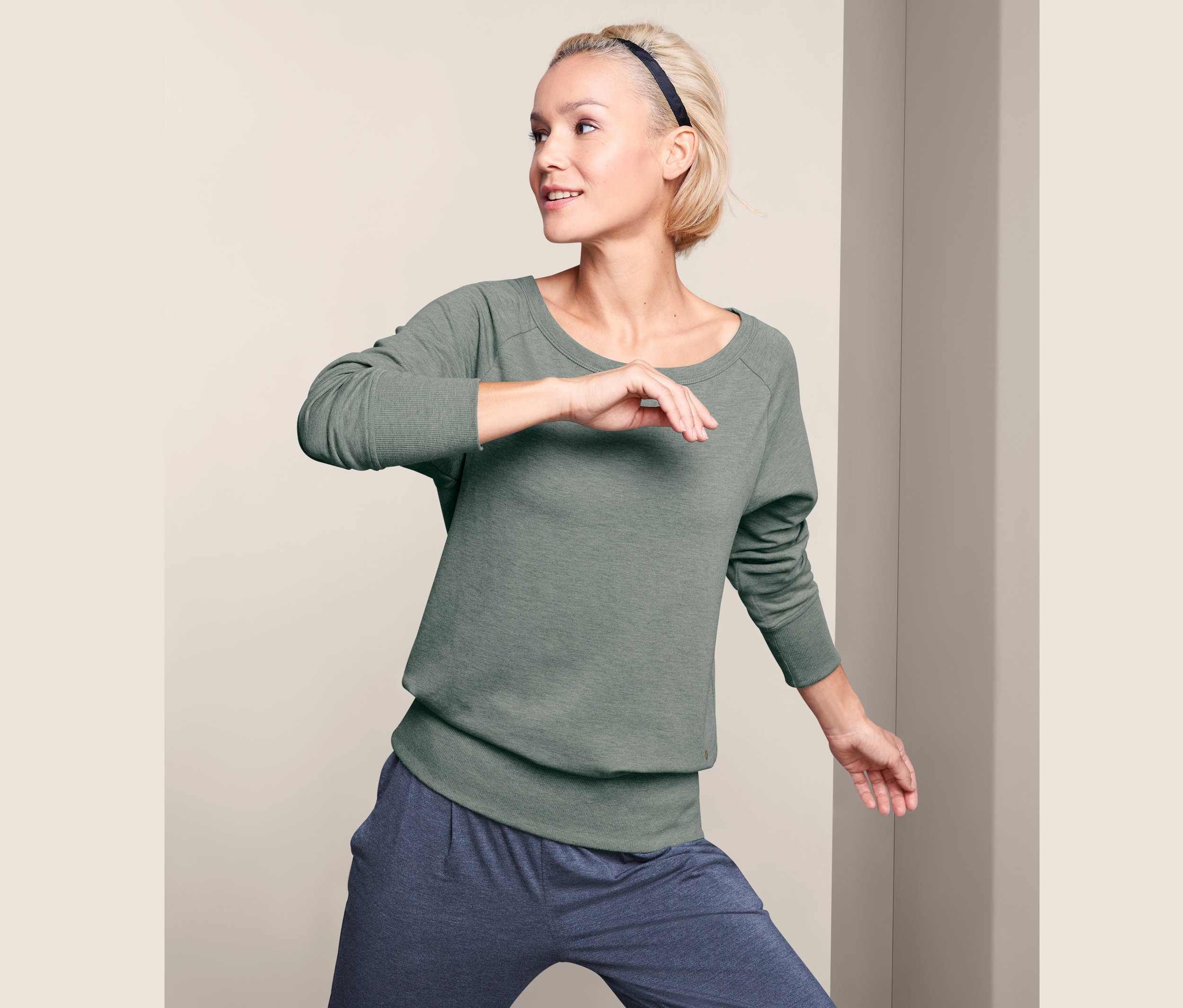 Frau posiert in Yogasweatshirt.
