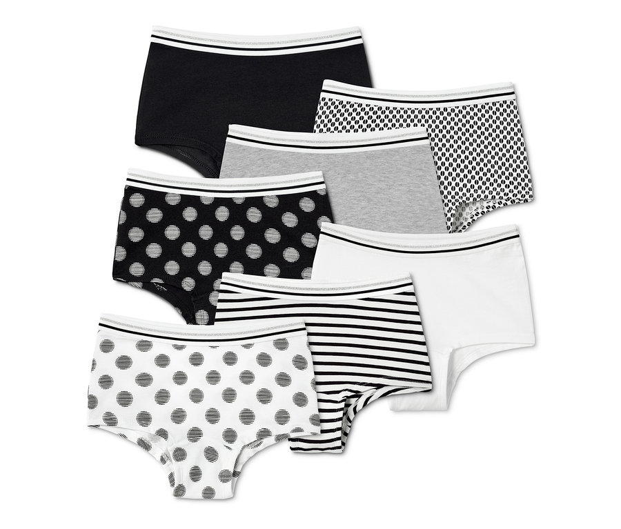Sieben Mädchen-Pantys in verschiedenen Mustern, schwarz, weiß, grau und bedruckt.