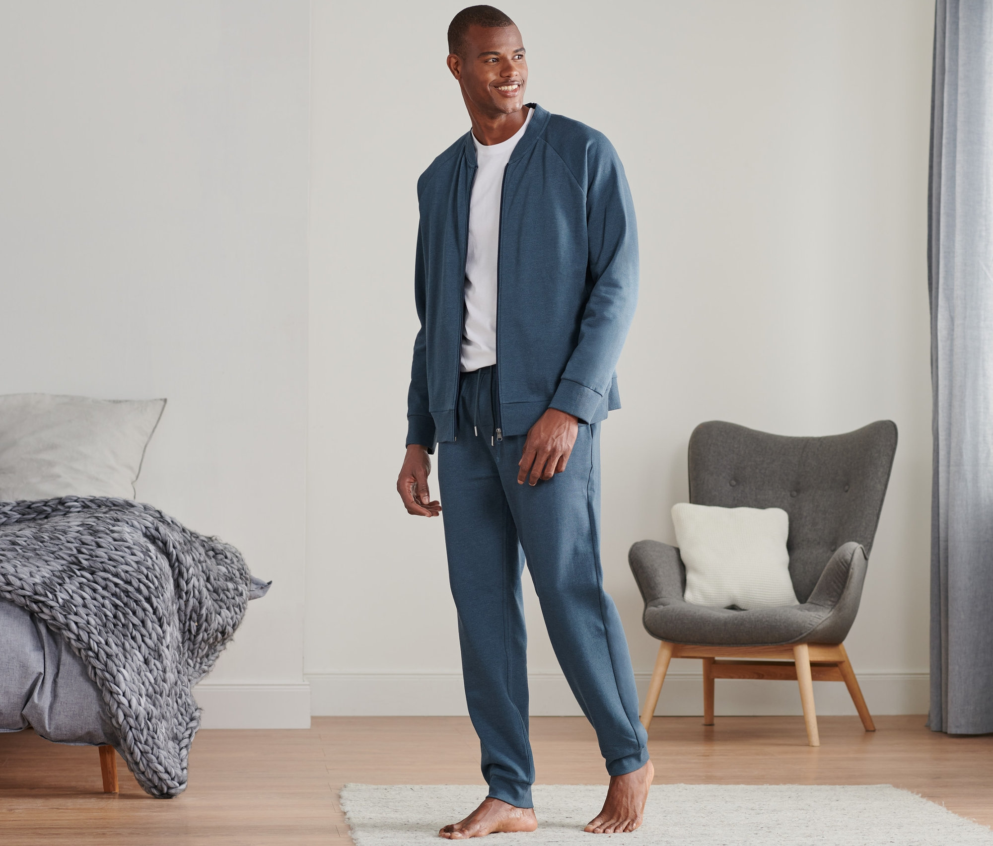 Mann trägt einen blauen Hausanzug im Zimmer.