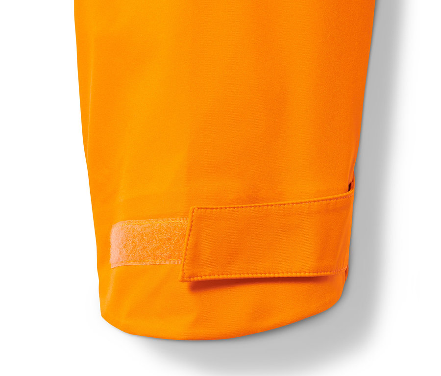 Detail einer orangefarbenen Hardshell-Skijacke mit Klettverschluss.
